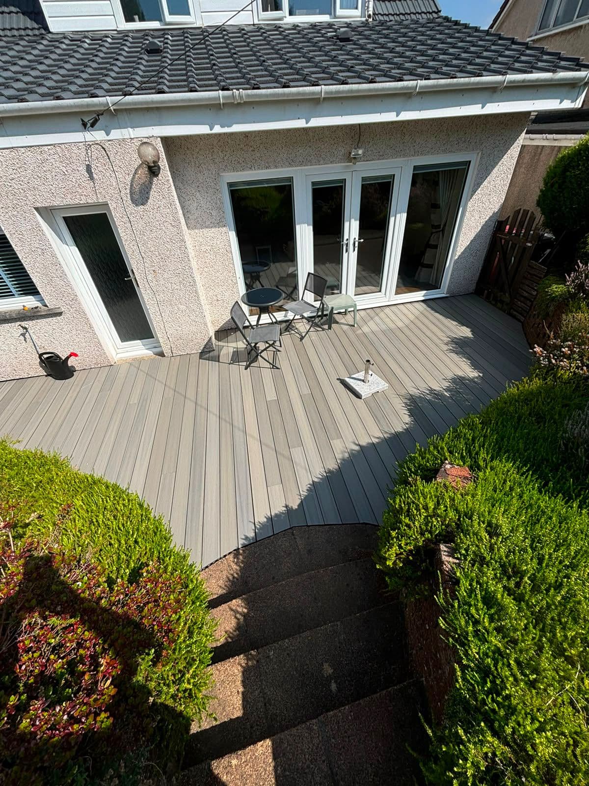 Grey composite decking finished beneath bi-fold doors