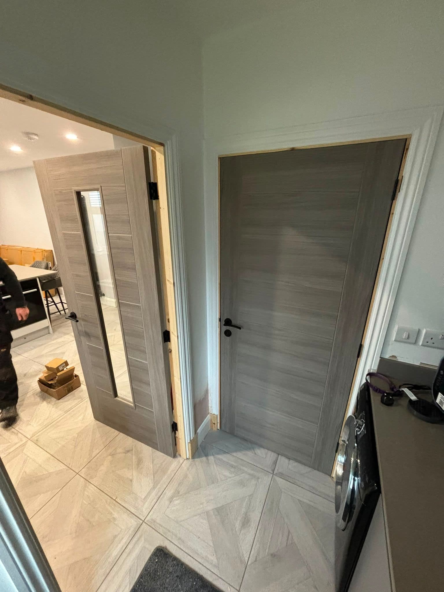 Grey woodgrain internal doors fitted with black lever handles
