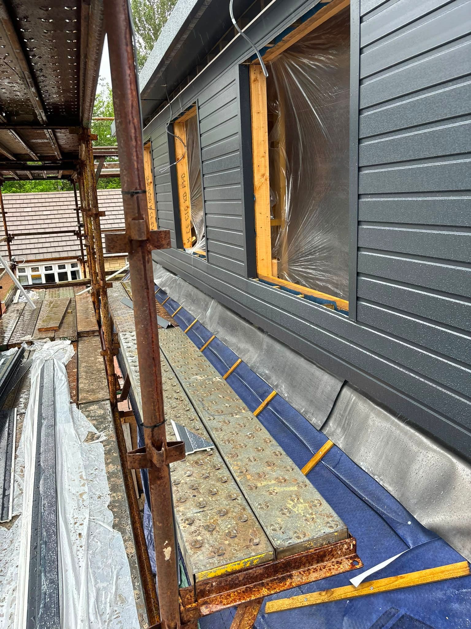 Grey composite cladding fitted around dormer window openings